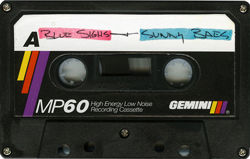 Auto-generated description: A vintage cassette tape labeled Blue Sighs - Sunny Rads is shown with colorful marker annotations.